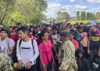 Migrants talk to Panamanian National Border Service members as they try to cross the border between Panama and Costa Rica while trying to return to Venezuela, at Paso Canoas between Panama and Costa Rica border on February 11, 2025. Dozens of Venezuelan migrants crossed the border from Costa Rica into Panama on Tuesday in a small caravan as they gave up the journey to the United States, overwhelmed by the grueling journey and fearful of Donald Trump's harsh anti-immigrant policies. (Photo by PAUL MONTENEGRO / AFP)